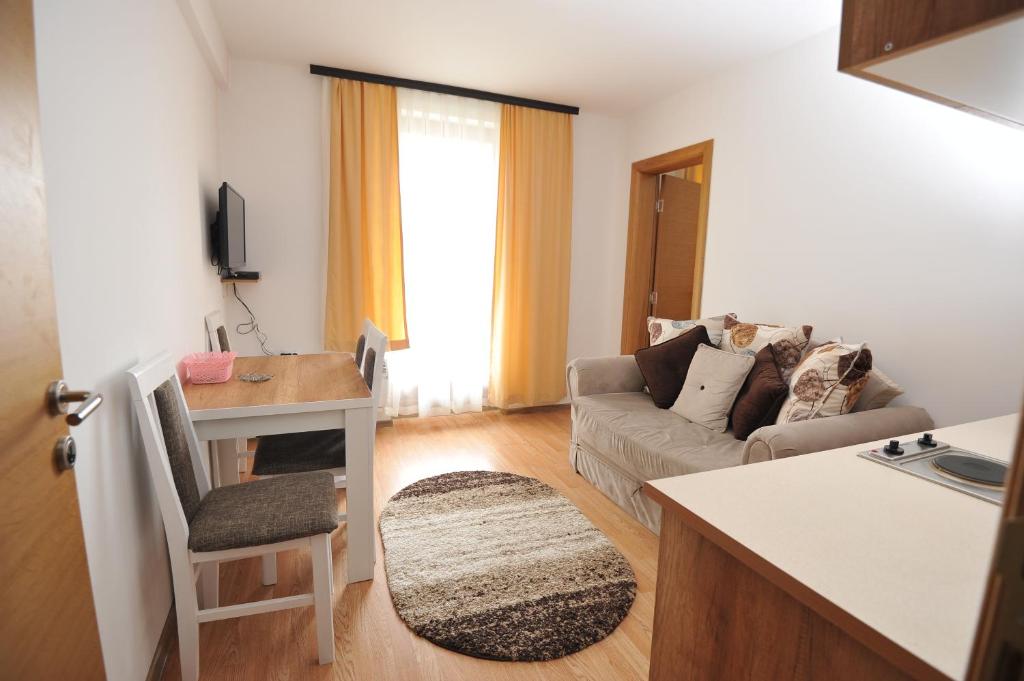 uma cozinha e sala de estar com um sofá e uma mesa em Kopaonik Apartman Sanja em Kopaonik