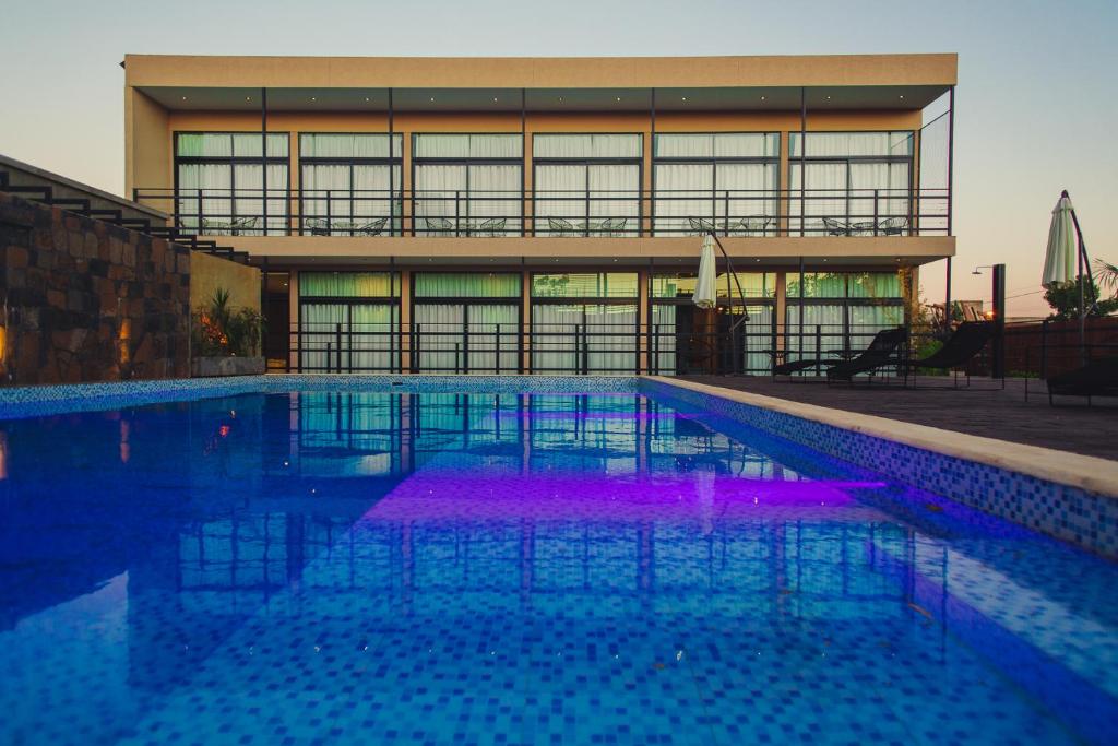 伊瓜蘇港的住宿－Paraiso Natural Apart Hotel Iguazu，一座建筑前的紫色游泳池