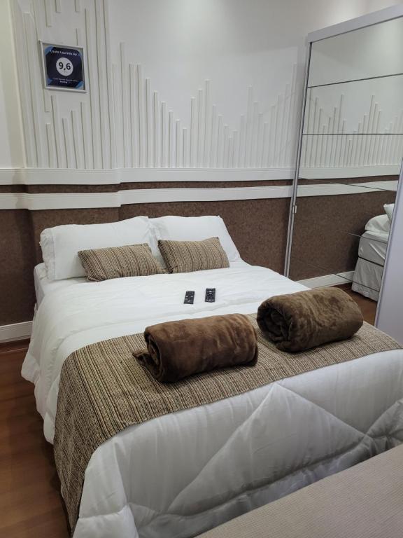 um quarto com 2 camas grandes com almofadas em Couto Lauredo Ap no Rio de Janeiro