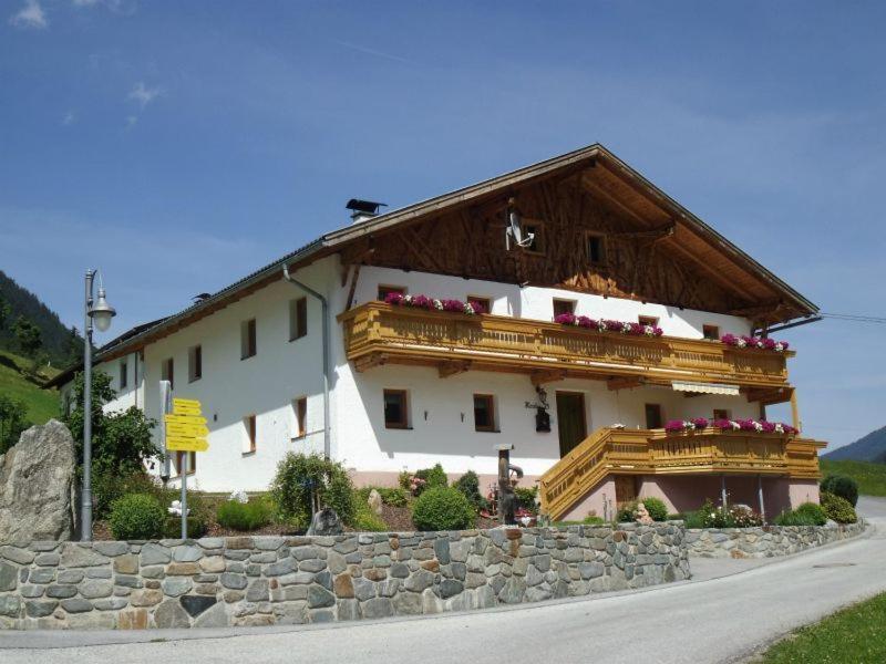 ein großes weißes Gebäude mit einem Holzdach in der Unterkunft Temelerhof in Gries im Sellrain