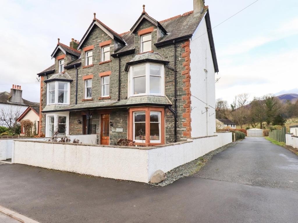 una casa vieja al lado de una carretera en Hazelmere en Keswick