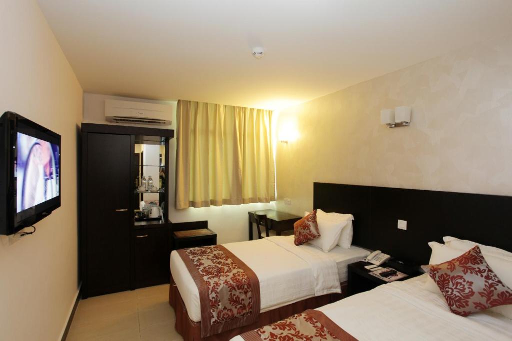 斗湖的住宿－我的酒店，酒店客房设有两张床和一台平面电视。