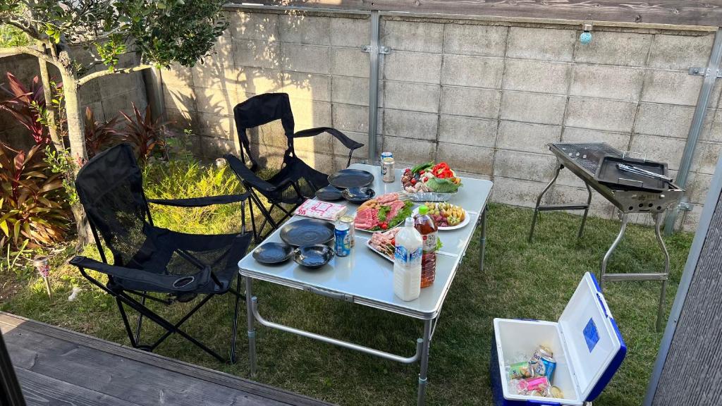 石垣島的住宿－rupo green，一张桌子,上面有食物,还有椅子和烤架
