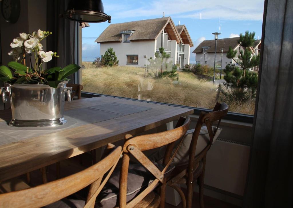 a table with two chairs in front of a window at Ostsee - Reetdachhaus Nr 44 "Reethüs - Marina" im Strand Resort in Heiligenhafen