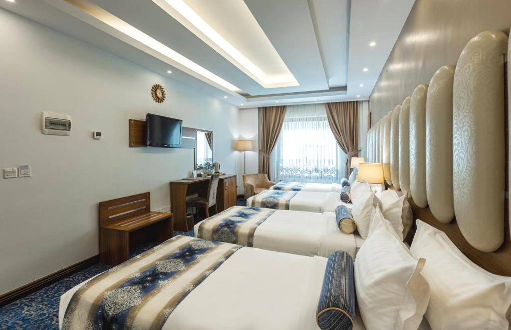 una camera d'albergo con due letti e una televisione di Grand Al Safi Hotel a Medina