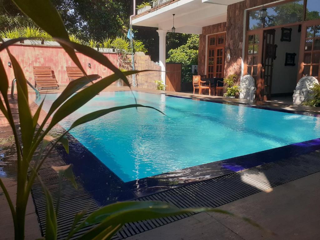 una piscina en un patio con una casa en Veraima Kandy en Kandy
