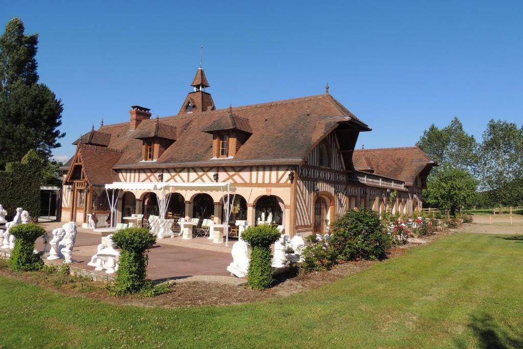 Le Manoir de Goliath في Toutainville: منزل خشبي كبير مع حديقة أمامه