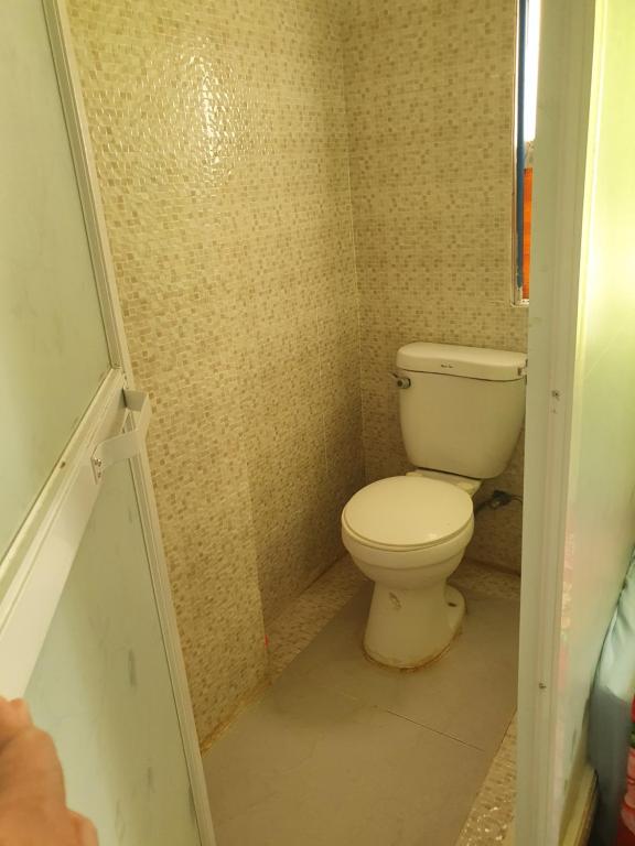 Casa Sarmiento Travellers Inn في لواوْغ: حمام مع مرحاض في غرفة صغيرة