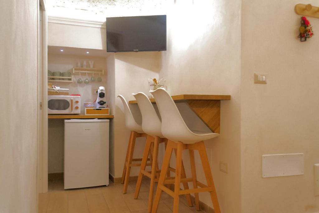 una cucina con bar con sgabelli e forno a microonde di Castrum Casa Vacanza a Mesagne