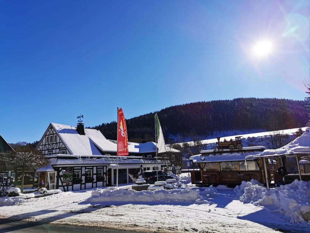 a ski lodge in the snow with piles of snow at Land-Hotel Mühlengrund in Winterberg