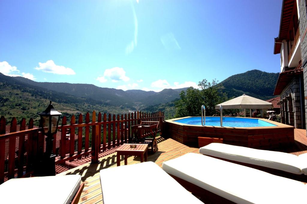 een patio met een zwembad en een terras met uitzicht bij Archontiko Metsovou Luxury Boutique Hotel in Metsovo