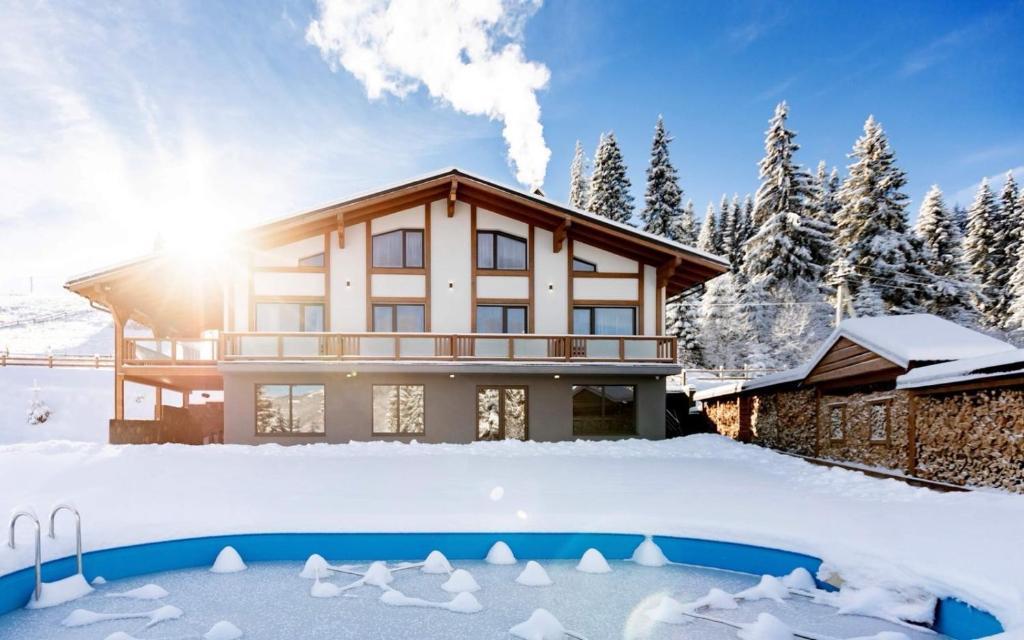 una casa nella neve con una piscina di TOPHILL House a Palyanytsya