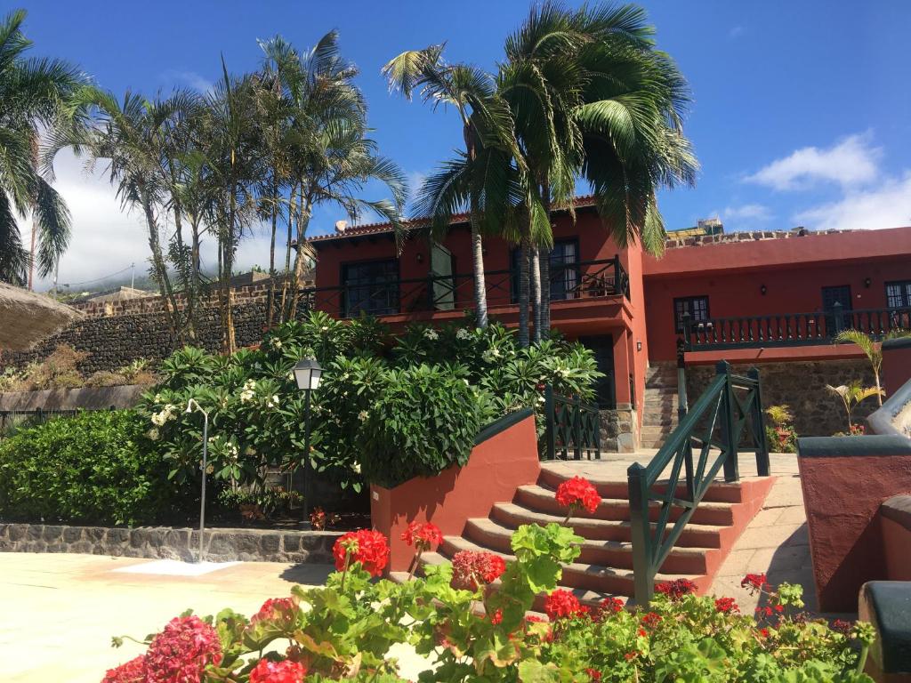 une maison avec des palmiers et des fleurs devant elle dans l'établissement Finca La Romera, à La Orotava