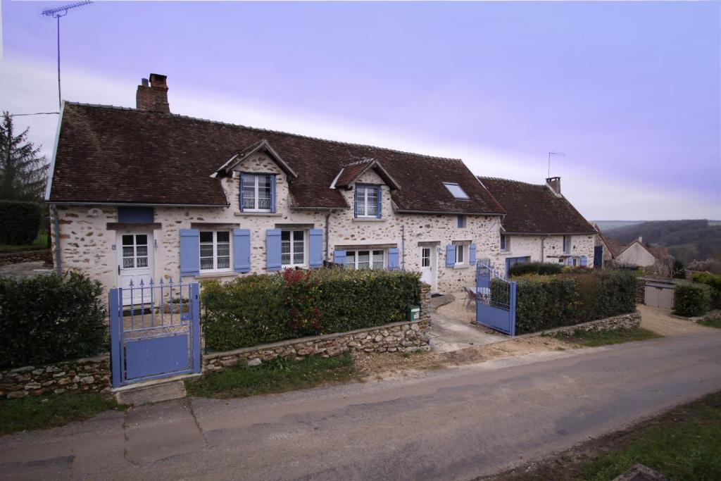 una vieja casa de piedra con una puerta azul en una calle en Gîte le Pilon, en Verdon