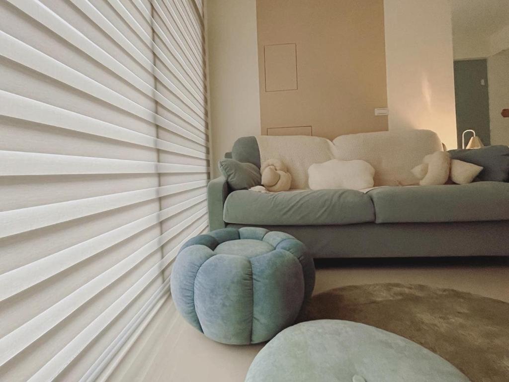 a living room with a couch and a blue ottoman at 禾樂號Hello House in Luodong