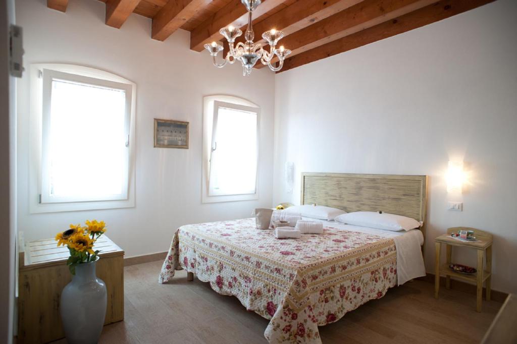 a bedroom with a bed and a vase with flowers at Villa Myosotis in Mirano