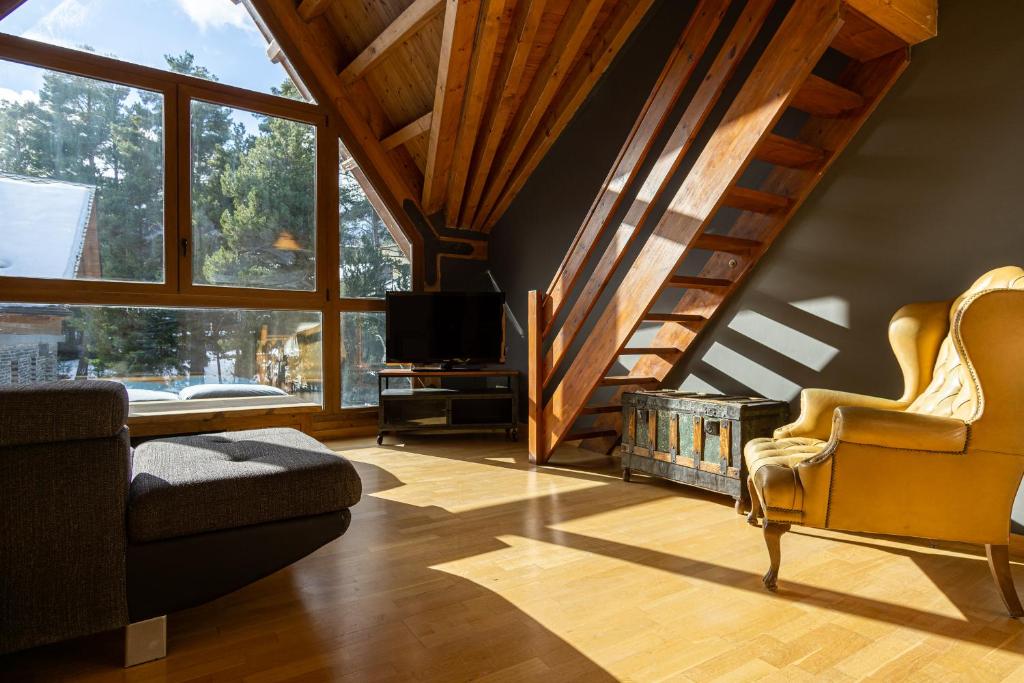 ein Wohnzimmer mit einer Treppe, einem Sofa und einem TV in der Unterkunft TRES OSSOS Apartamento vacacional in La Molina