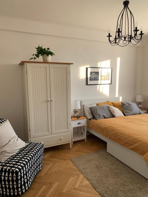 ein Schlafzimmer mit einem Bett und einem Schrank mit einer Pflanze darauf in der Unterkunft Apartment Anenská by Charles Bridge in Prag