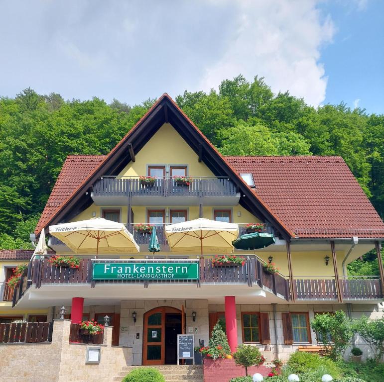 ein Gebäude mit Sonnenschirmen davor in der Unterkunft Hotel Landgasthof Frankenstern in Gößweinstein