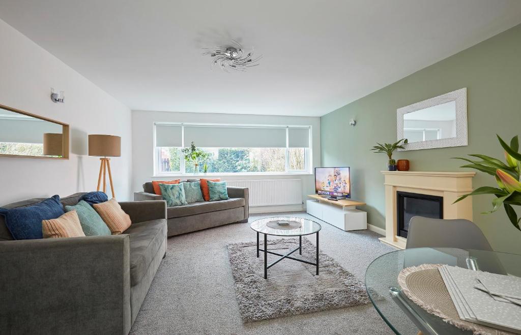 uma sala de estar com um sofá e uma lareira em Foxcroft em Brighouse