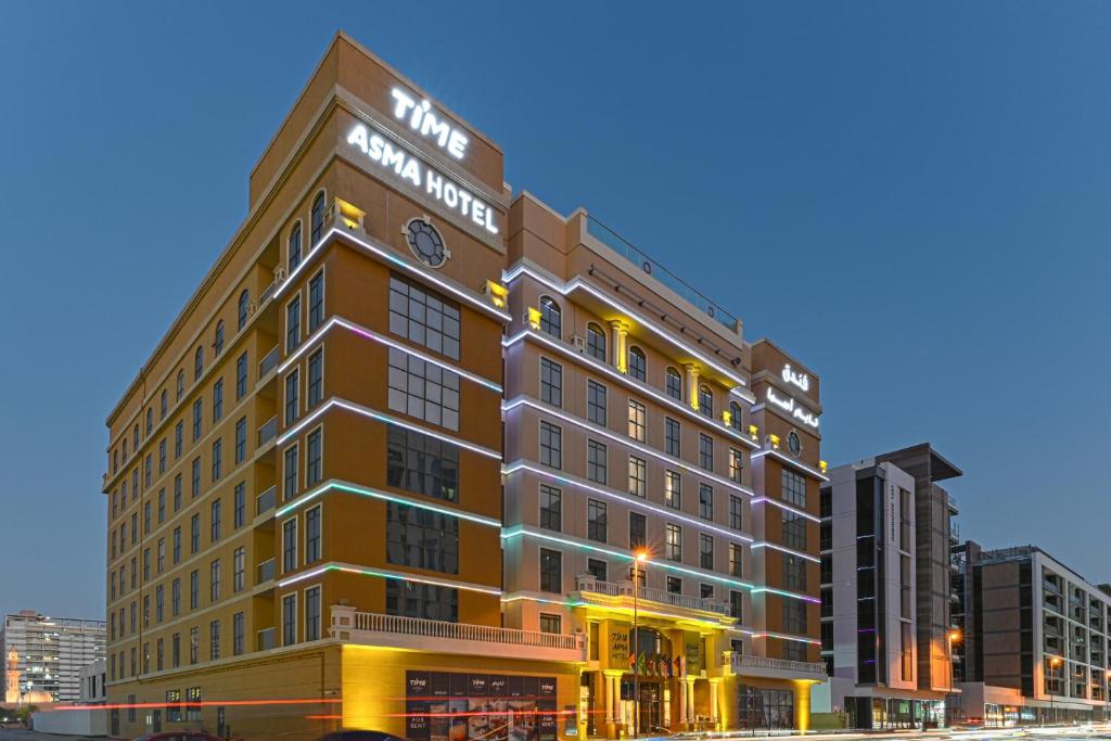 a large building with a clock on top of it at TIME Asma Hotel in Dubai