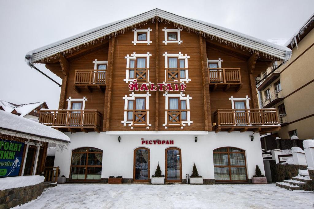 un gran edificio de madera con un cartel. en Altair Hotel, en Bukovel