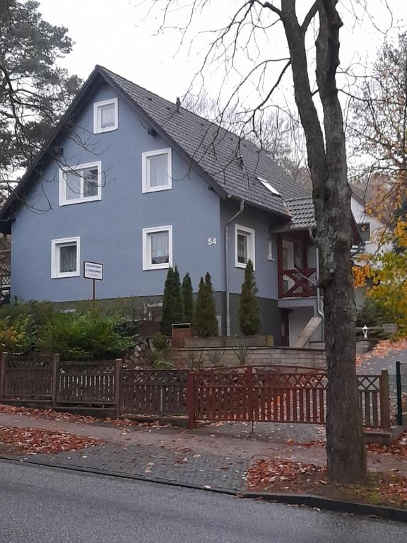 ein blaues Haus mit einem Zaun davor in der Unterkunft Ferienwohnung Kastanienblick mit Wlan in Bansin