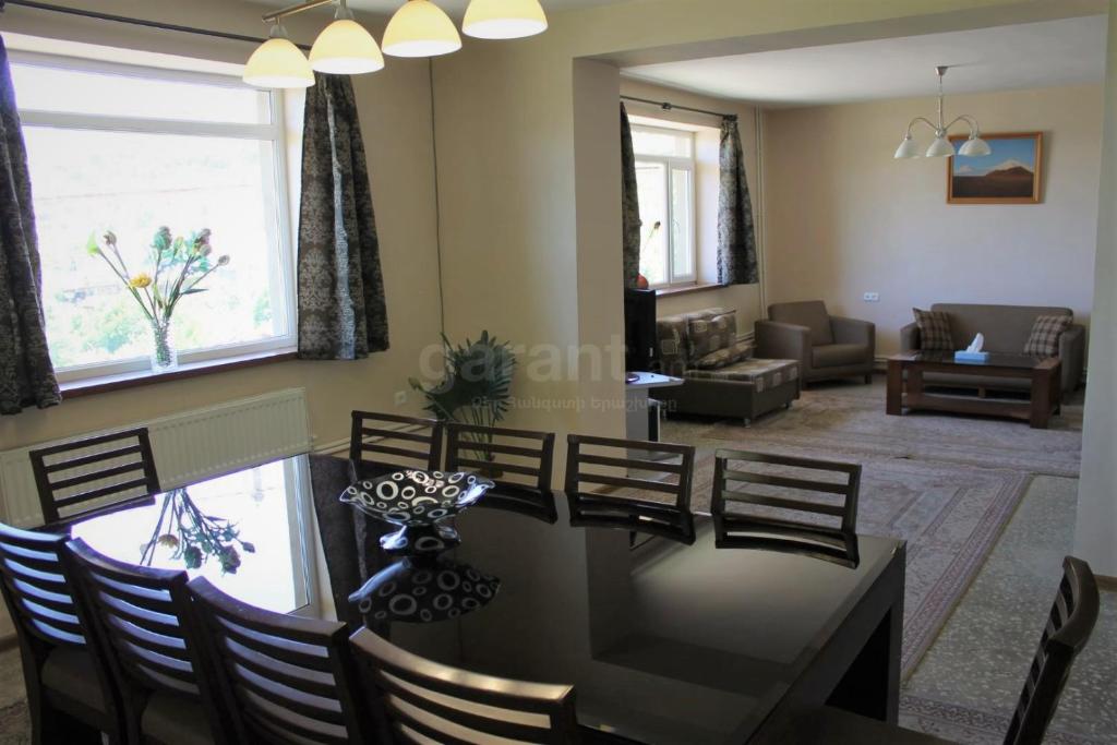 a dining room and living room with a table and chairs at Space Grey Villa - Вилла с 5 спальнями в центре Цахкадзора in Tsaghkadzor