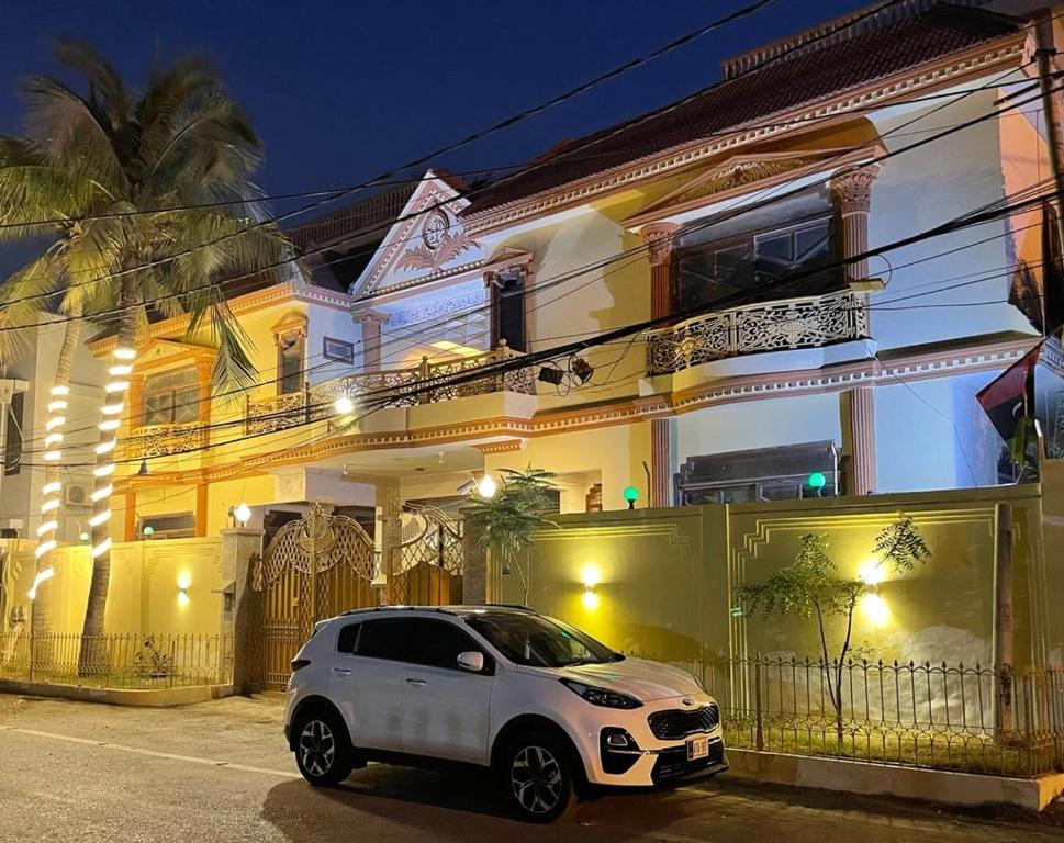 a white car parked in front of a building at Hotel Seven 7 in Karachi