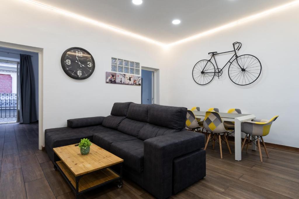 a living room with a couch and a bike on the wall at vip CERVANTES, by MONARO***** in Madrid