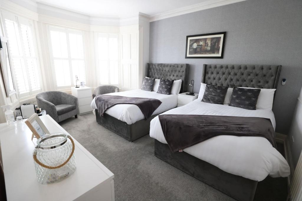 a bedroom with two beds and a chair at Mandalay in Portrush