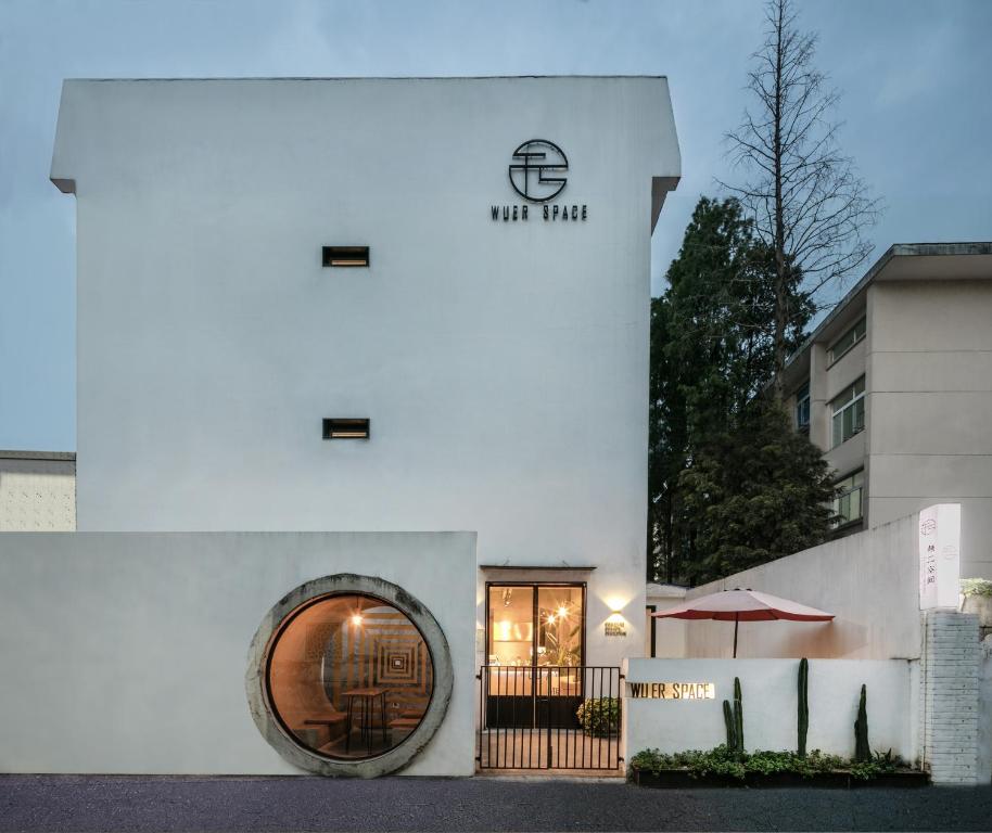 a white building with a round window and an umbrella at Suzhou Unique Space Design Art Hotel in Suzhou