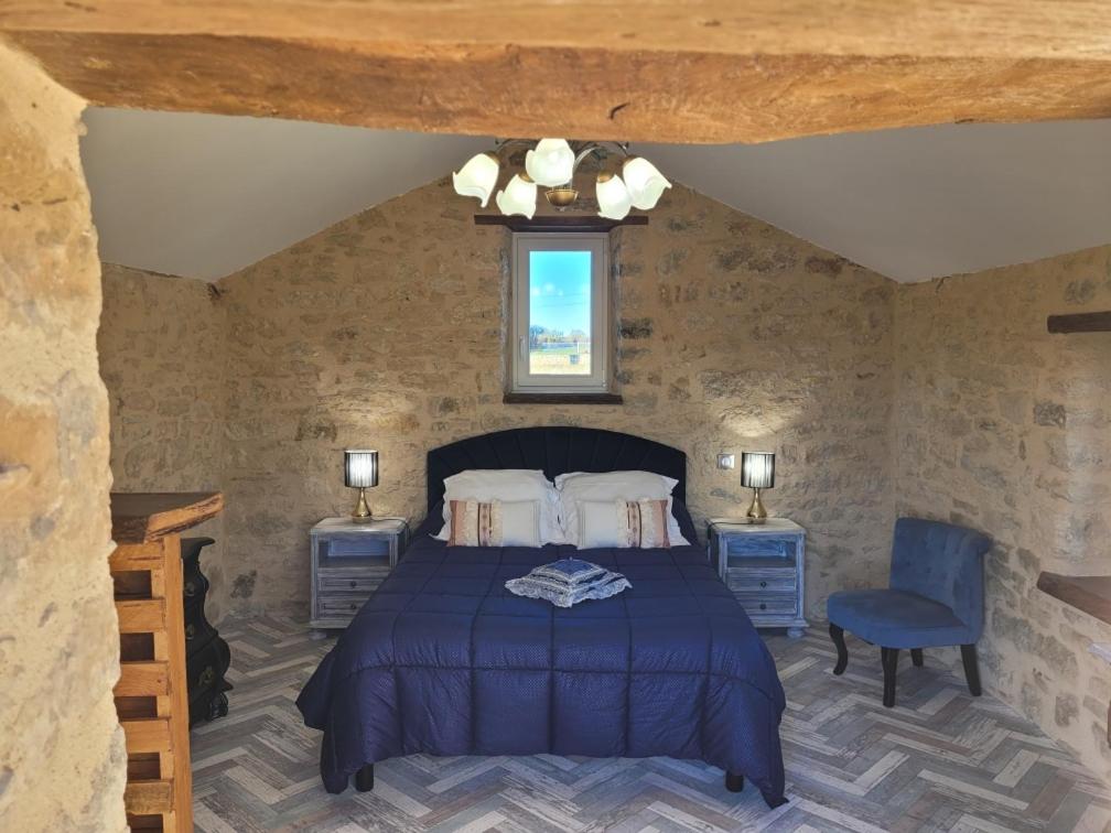 um quarto com uma cama e uma cadeira azul em cazelle em Figeac