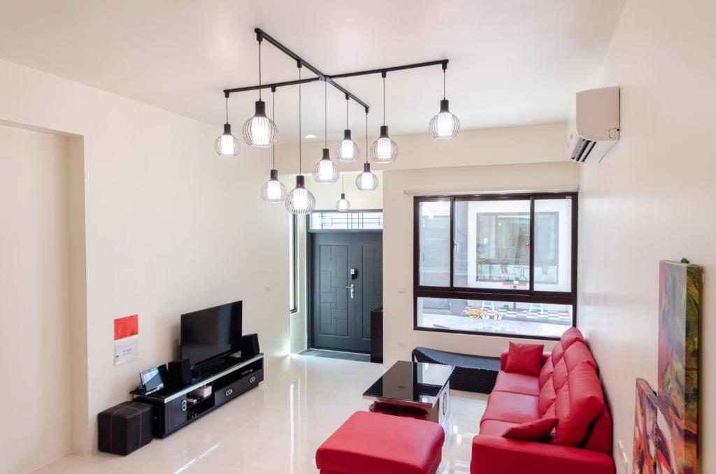 a living room with a red couch and a tv at Touch 星空包棟民宿寵物友善民宿 in Wujie
