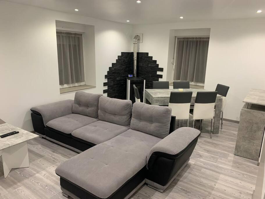 a living room with a couch and a table at Appartement neuf, au coeur du massif Vosgien in Fraize