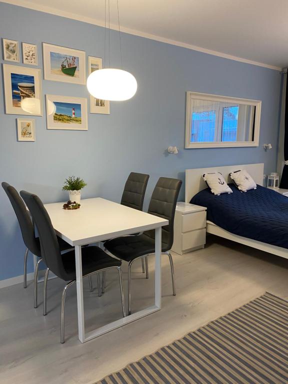 ポゴジェリツァにあるApartament Nautica Pogorzelicaのベッドルーム(テーブル、椅子、ベッド付)