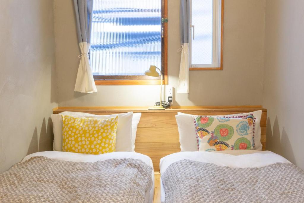 a room with two cushions and a window at Tokyo Hikari Guesthouse in Tokyo