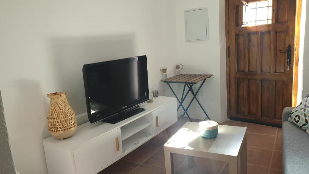 uma sala de estar com uma televisão de ecrã plano num armário branco em La Casita de Guille em Montejaque