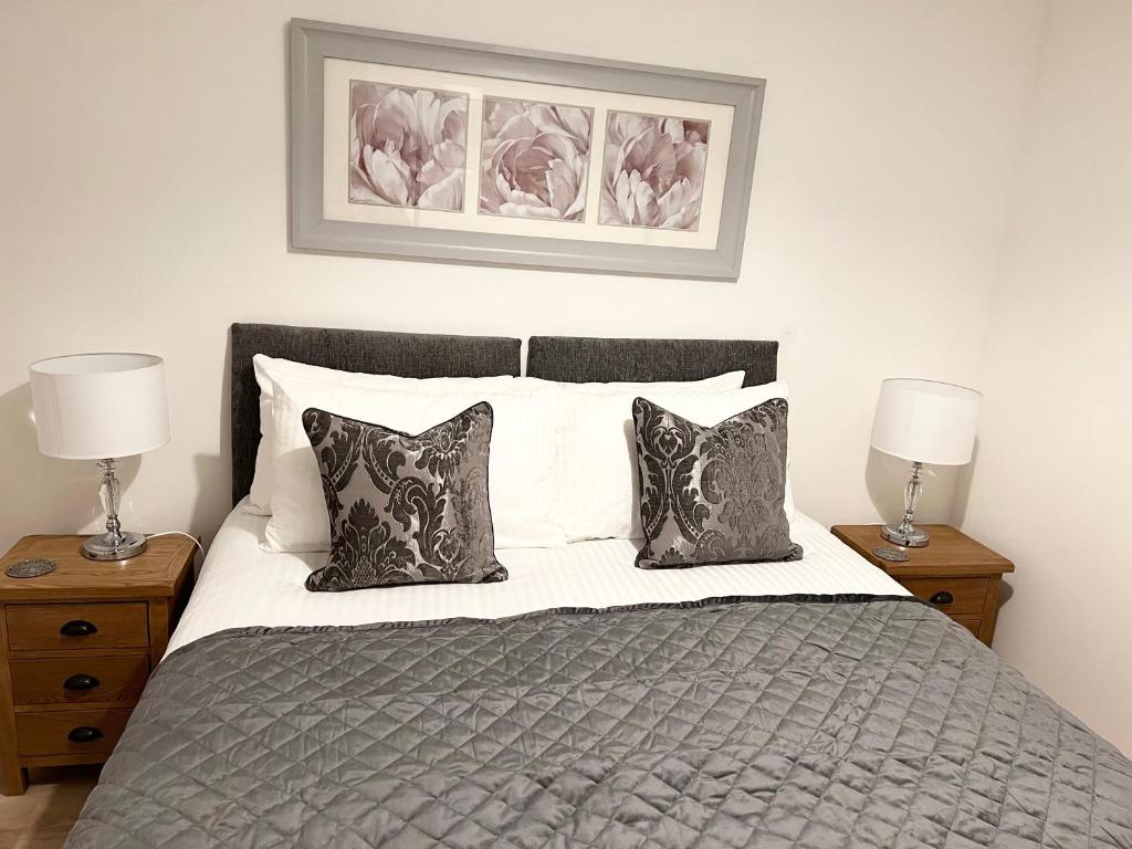 a bedroom with a bed with two night stands and two lamps at Waterloo Townhouse Inverness in Inverness