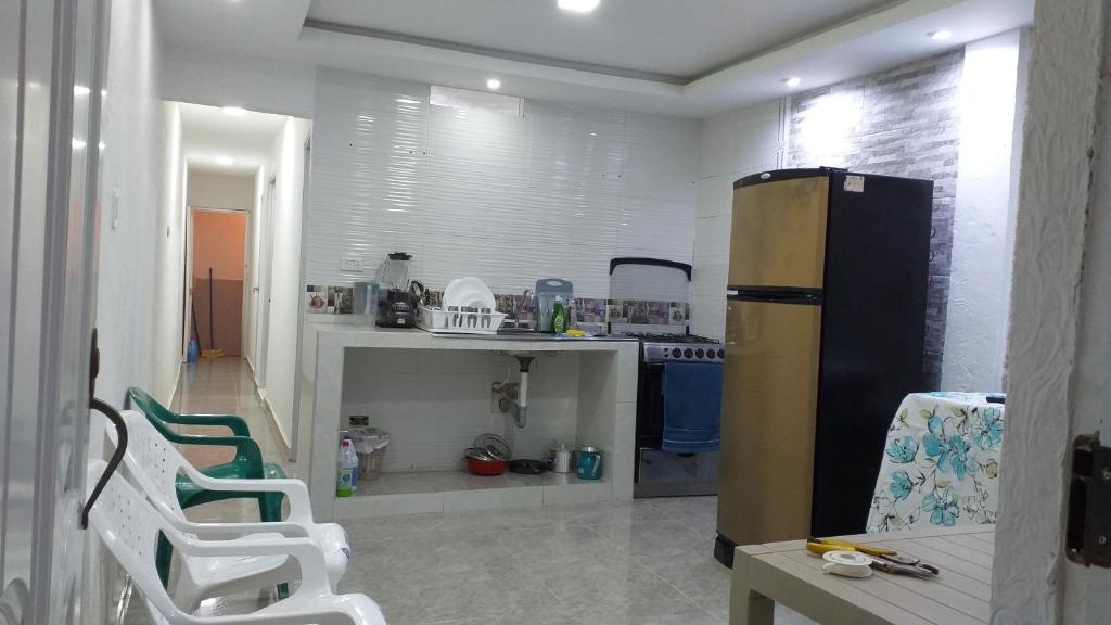 eine Küche mit einem Kühlschrank und 2 Stühlen in der Unterkunft Apartamento como en casa in Soledad