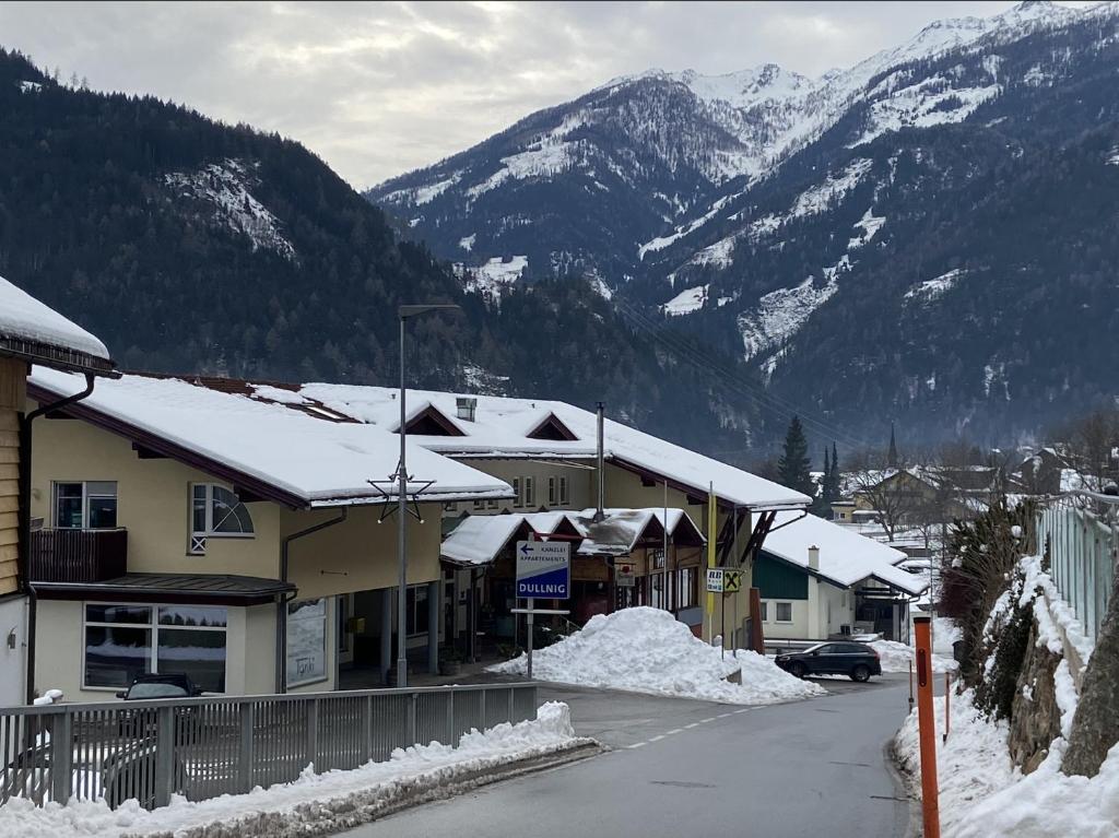 フラタッハにあるMölltaler Gletscher Apartmentの雪に覆われた建物や山々が並ぶ小さな町