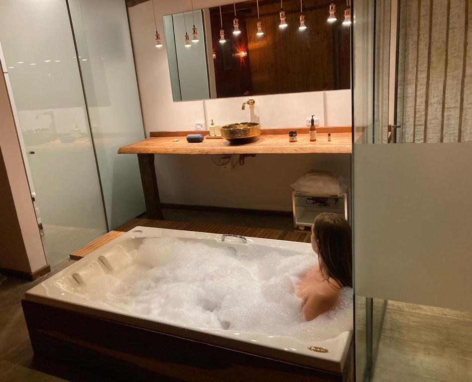 戈亞斯州上帕萊索的住宿－普薩達阿爾法歐米茄酒店，妇女在浴室的浴缸里