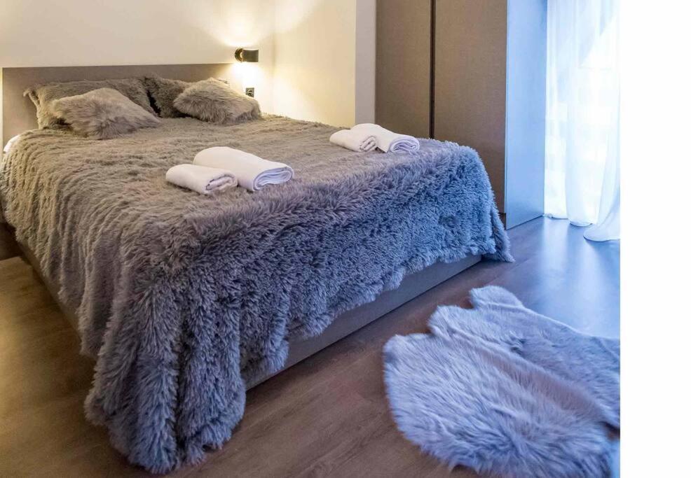 a bedroom with a bed with a blue blanket and two pillows at Ski Escape Apartment in Gudauri in Gudauri