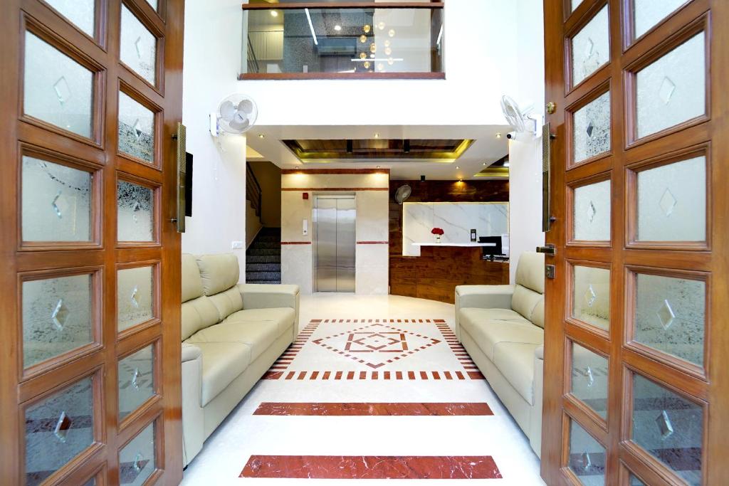 een woonkamer met 2 banken en een tapijt bij SS CROWN inn in Bangalore