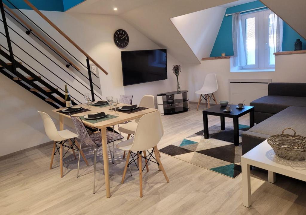 sala de estar con mesa, sillas y sofá en Cosis Colmar - 2 Chambres - 4 Pers - Duplex - Parking - Wifi, en Colmar
