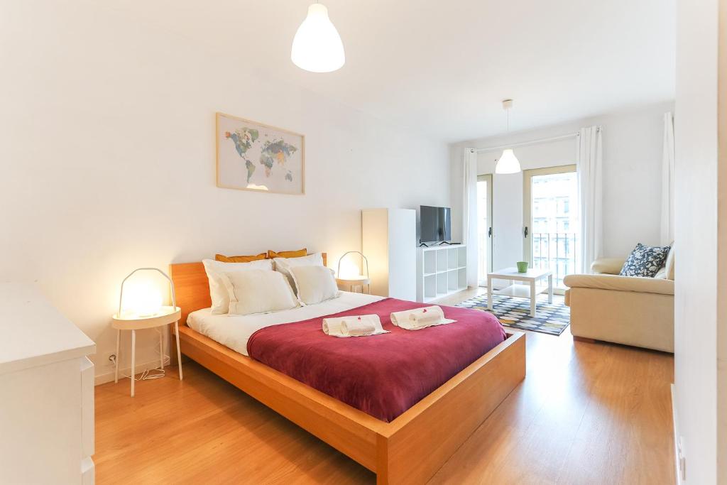 a bedroom with a large bed and a living room at Vita Portucale ! Charming Loft with Garage in Lisbon