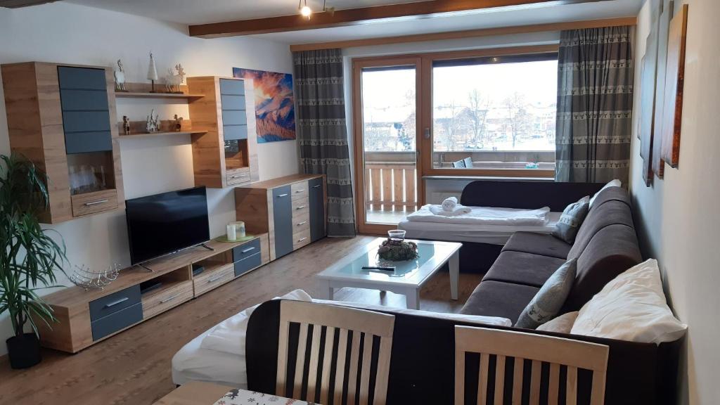 ein Wohnzimmer mit einem Sofa und einem TV in der Unterkunft Apartment Romy in Kaprun