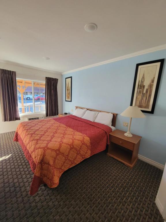 a hotel room with a bed with a red comforter at Townhouse Motel in Bishop