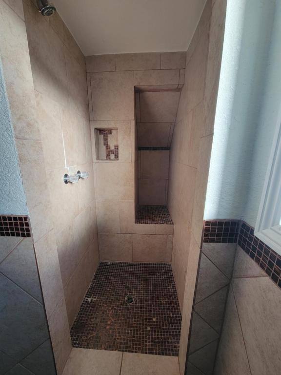 a walk in shower with a glass door at Townhouse Motel in Bishop