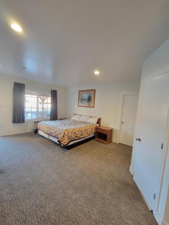a bedroom with a bed and a dresser and a window at Townhouse Motel in Bishop